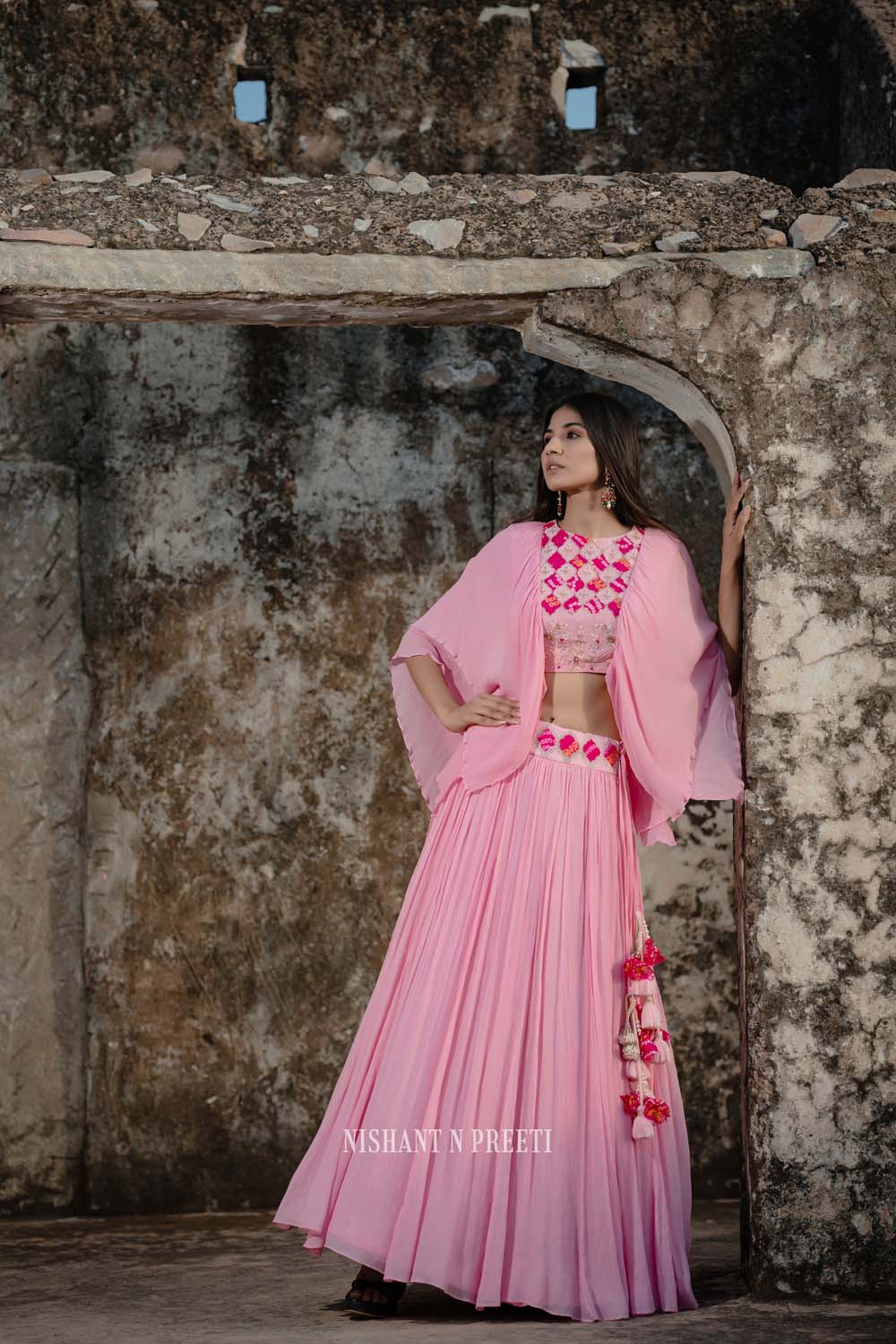 BRICK BLUSH PINK LEHENGA AND A CONTRAST IVORY OFF THE SHOULDER BLOUSE WITH  MULTI COLOURED EMBROIDERY AND “ABLA” PAIRED WITH A MATCHING PINK DUPATTA  AND TASSELS - Seasons India